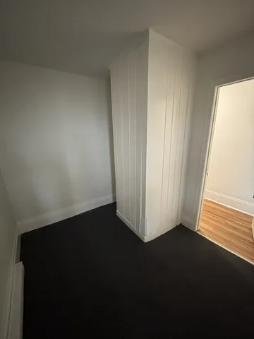 a view of a small space with wooden floor and a window