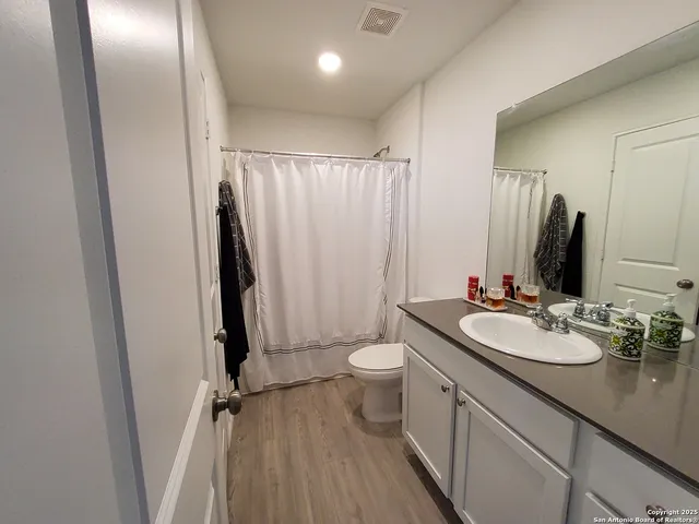 a bathroom with a double vanity sink toilet and a mirror