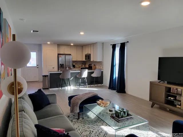 a living room with furniture a flat screen tv and a table