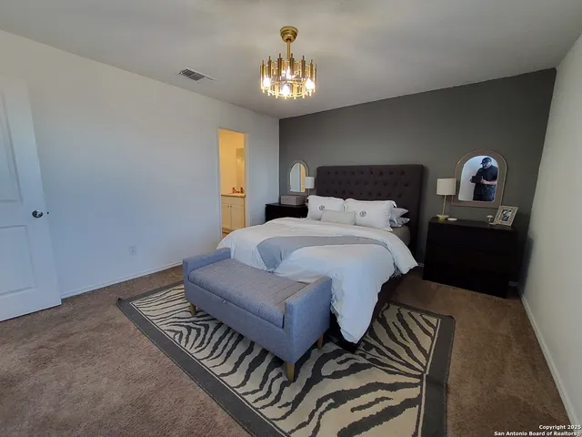 a bedroom with a bed and a chandelier