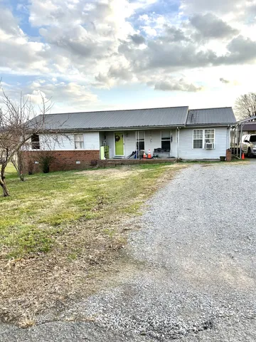 a view of a house with a yard and a garage