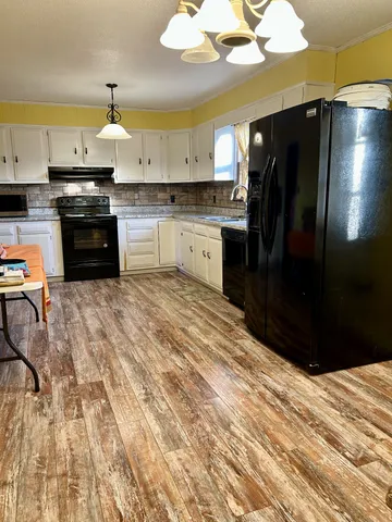 a kitchen with stainless steel appliances granite countertop a refrigerator a stove and a sink