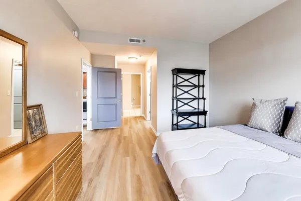 a spacious bedroom with a bed and a large mirror
