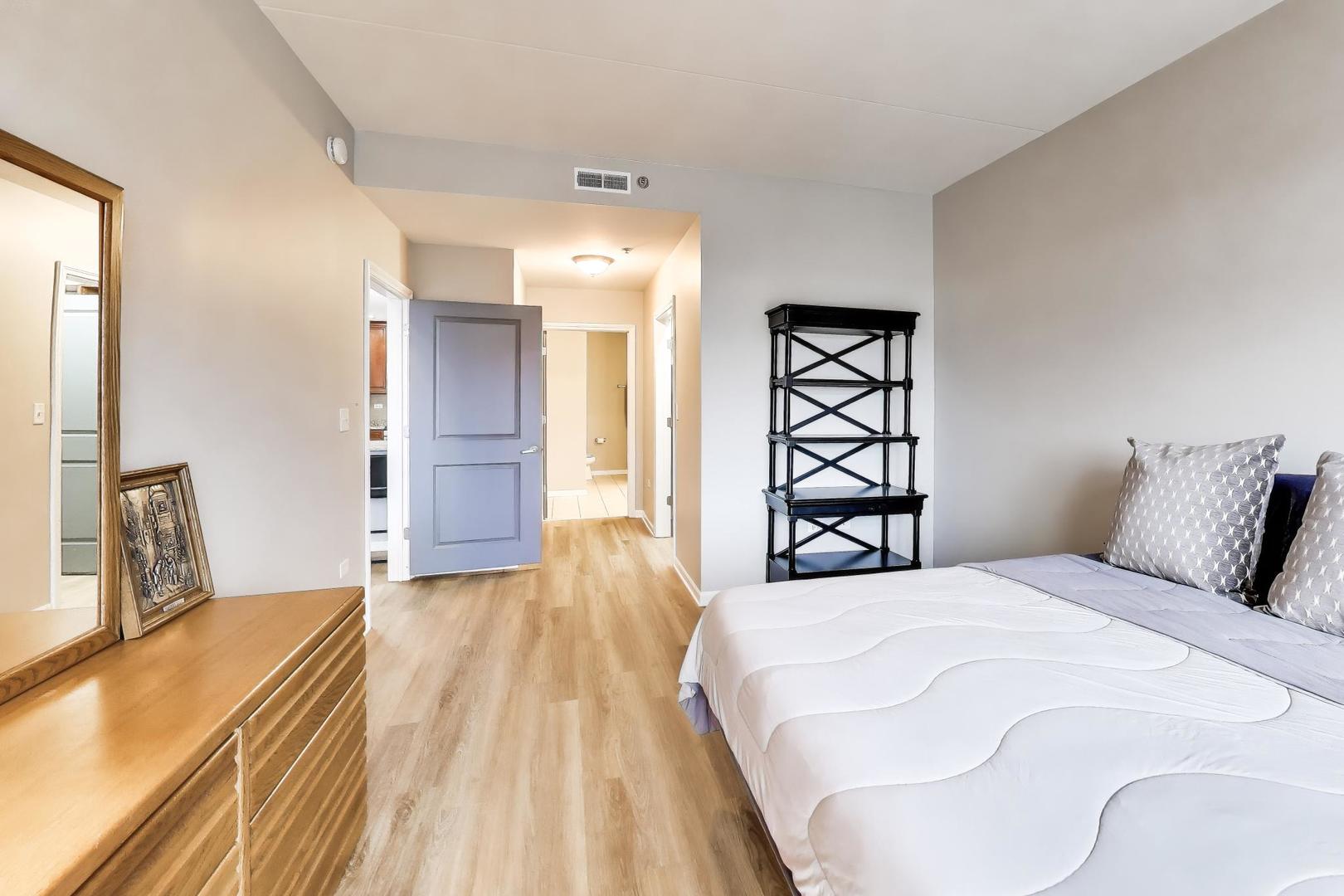 1199 East Port Clinton Road, Unit 311 Vernon Hills, IL 60061 - Photo 12 of 23 a spacious bedroom with a bed and a large mirror