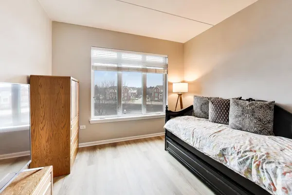 a large bedroom with a bed and wooden floor