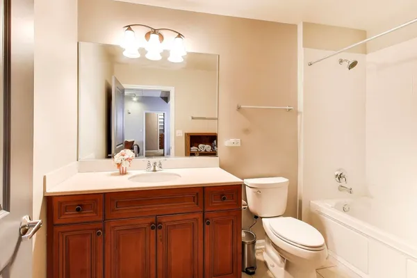 a bathroom with a sink a toilet a mirror and shower