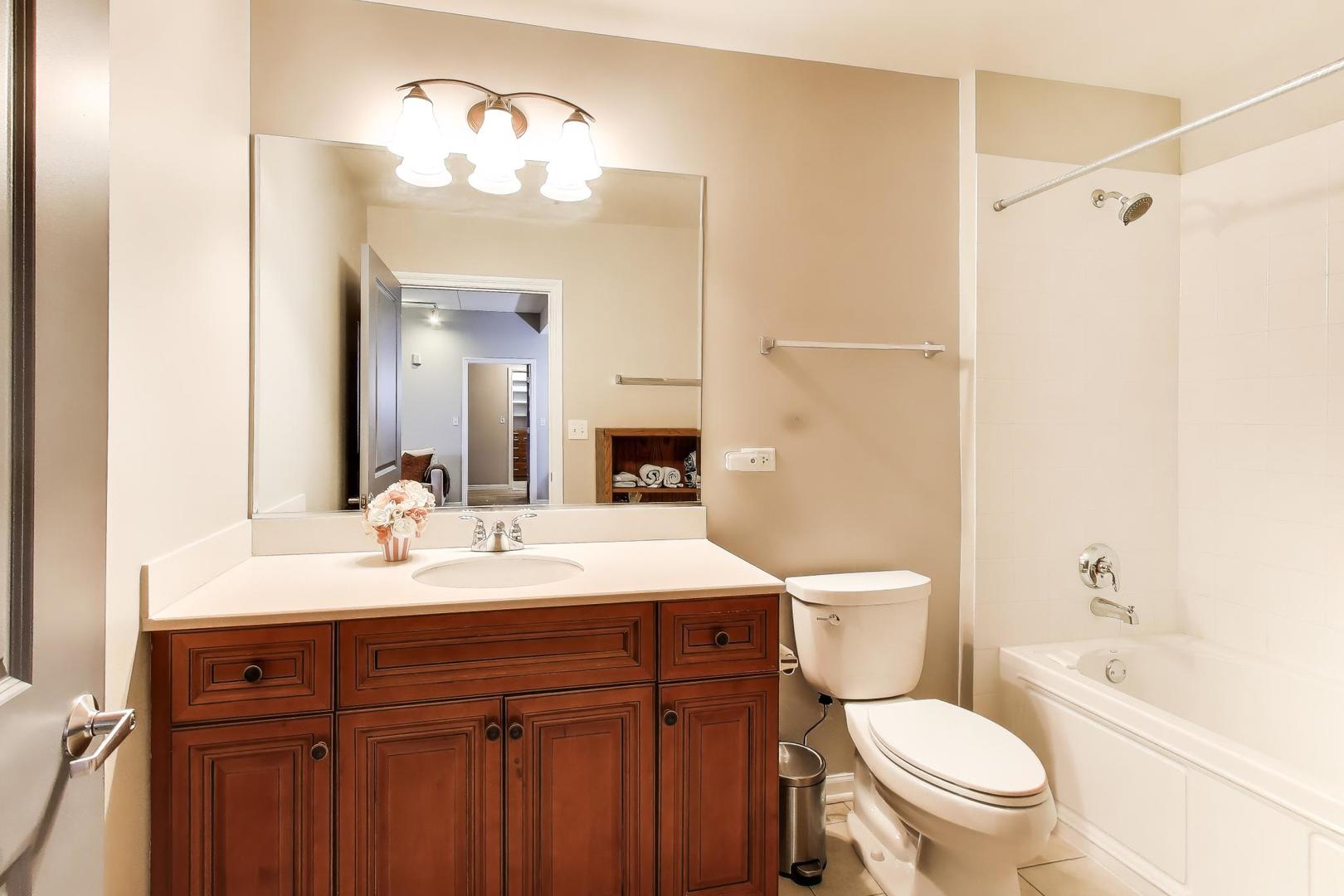 1199 East Port Clinton Road, Unit 311 Vernon Hills, IL 60061 - Photo 17 of 23 a bathroom with a sink a toilet a mirror and shower