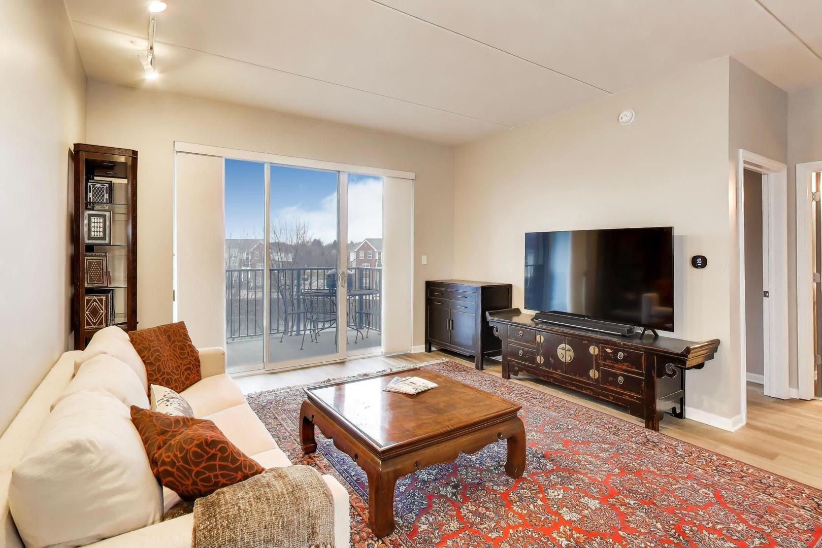 1199 East Port Clinton Road, Unit 311 Vernon Hills, IL 60061 - Photo 5 of 23 a living room with furniture and a flat screen tv