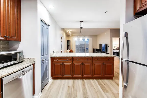 a large kitchen with stainless steel appliances a refrigerator and a sink