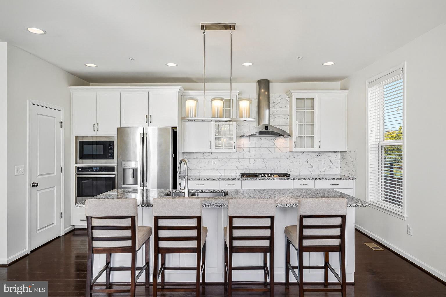 14580 Lakestone Drive Chantilly, VA 20151 - Photo 2 of 21 a kitchen with stainless steel appliances kitchen island granite countertop a stove and white cabinets