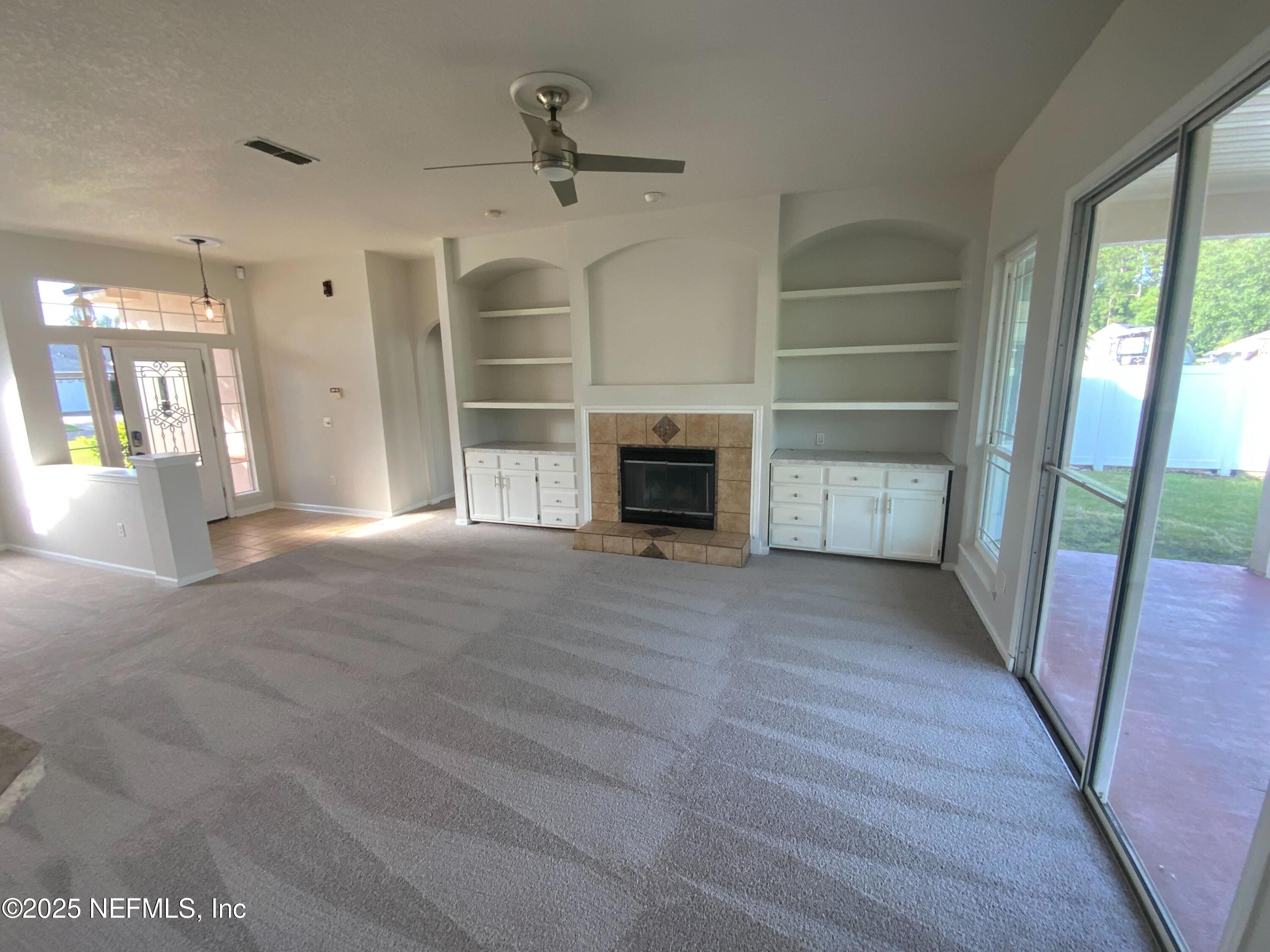 9767 Brockham Court Jacksonville, FL 32221 - Photo 11 of 17 a view of empty room with wooden floor and fireplace