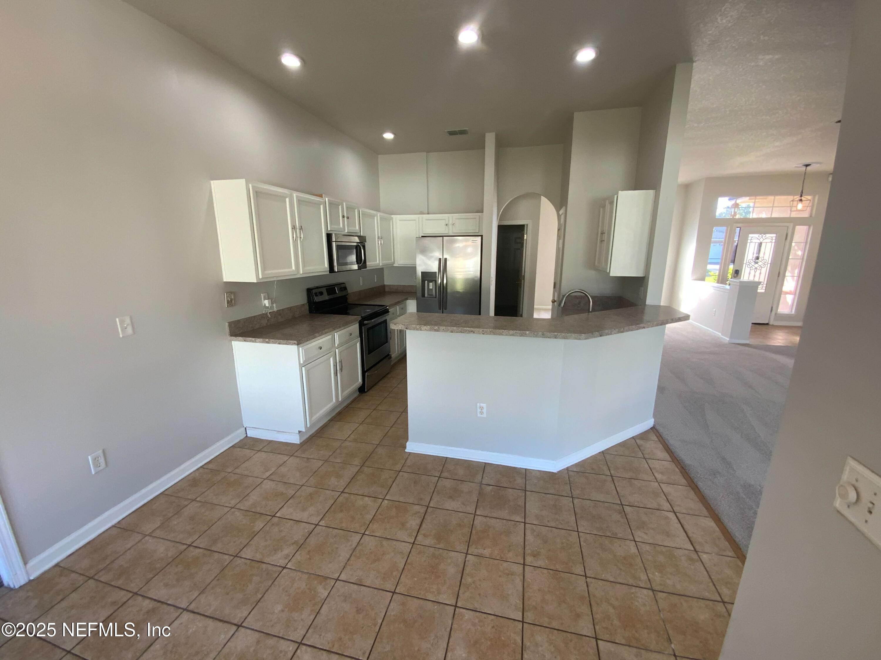 9767 Brockham Court Jacksonville, FL 32221 - Photo 15 of 17 a kitchen with stainless steel appliances a refrigerator sink and microwave
