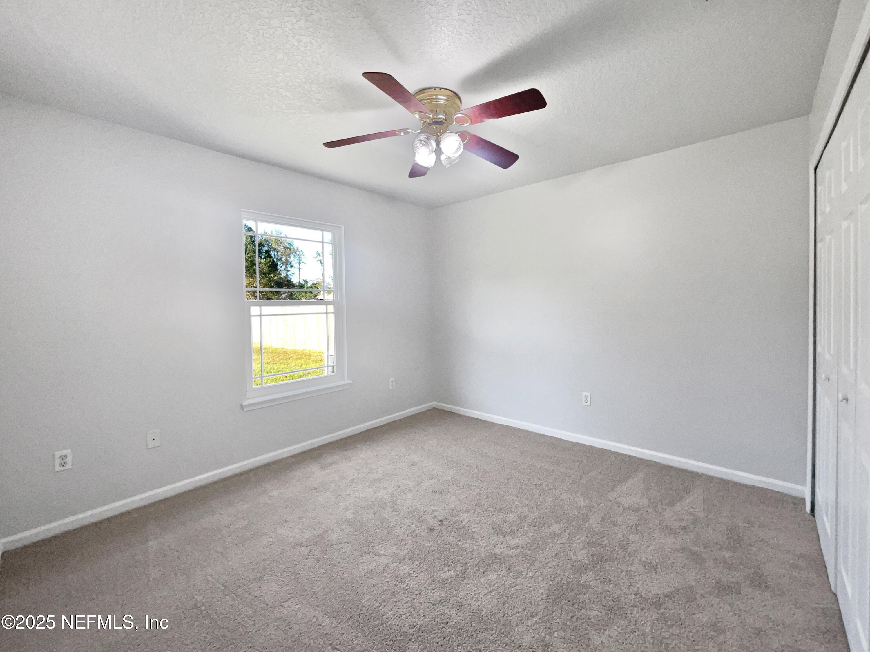 9767 Brockham Court Jacksonville, FL 32221 - Photo 2 of 17 an empty room with a window and a ceiling fan