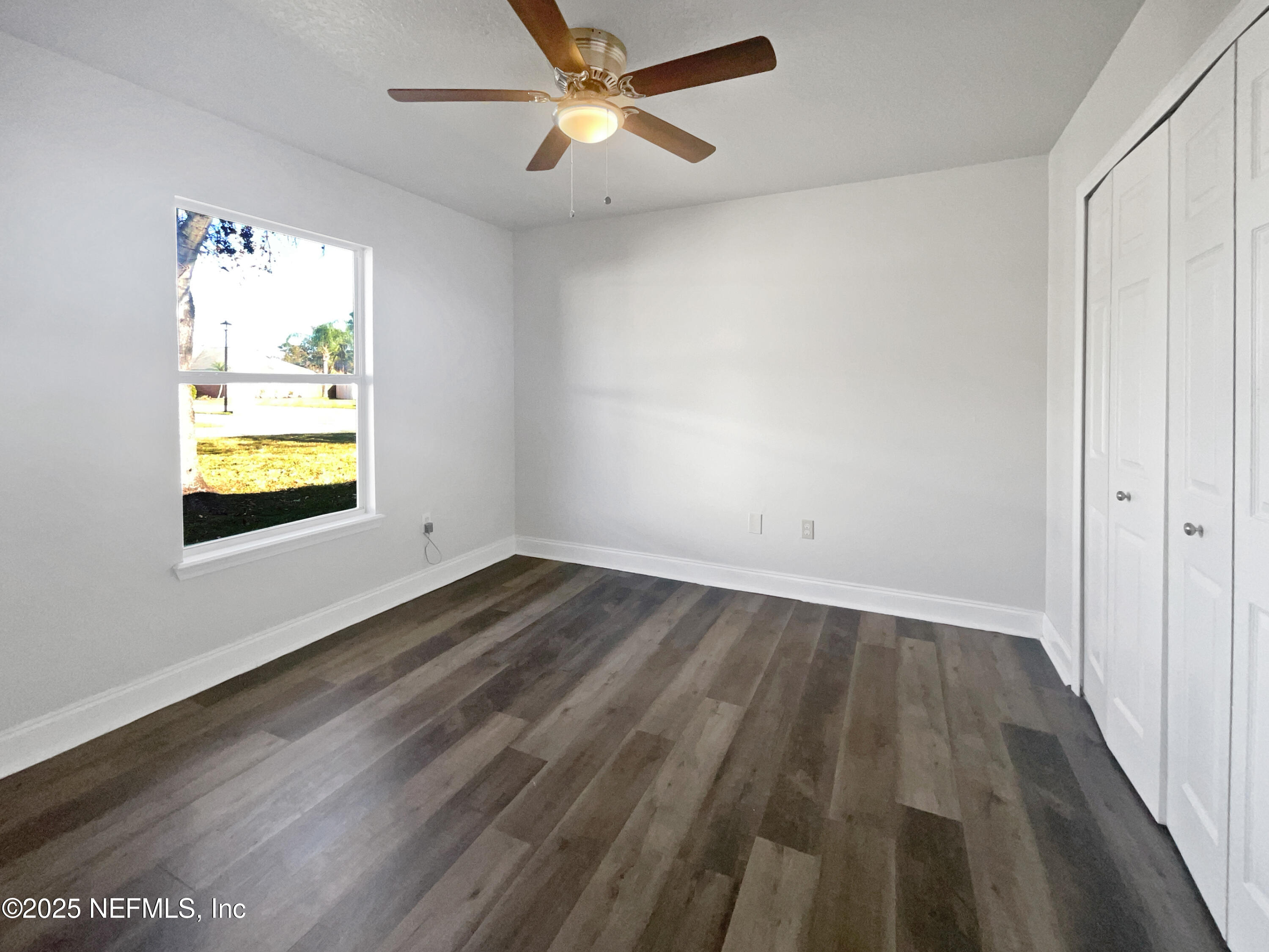 9767 Brockham Court Jacksonville, FL 32221 - Photo 7 of 17 wooden floor in an empty room with a window