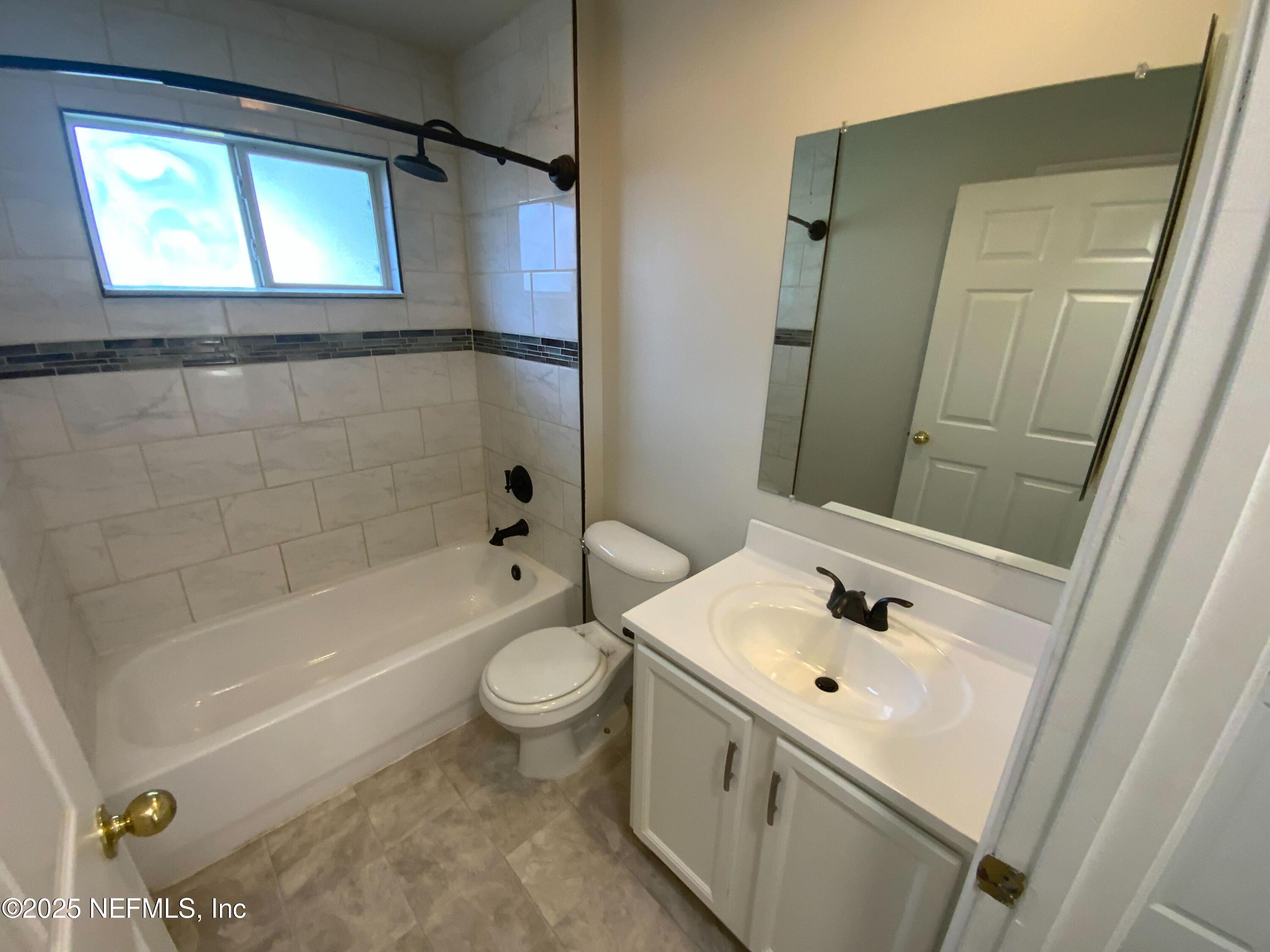 9767 Brockham Court Jacksonville, FL 32221 - Photo 9 of 17 a bathroom with a sink mirror toilet and bathtub