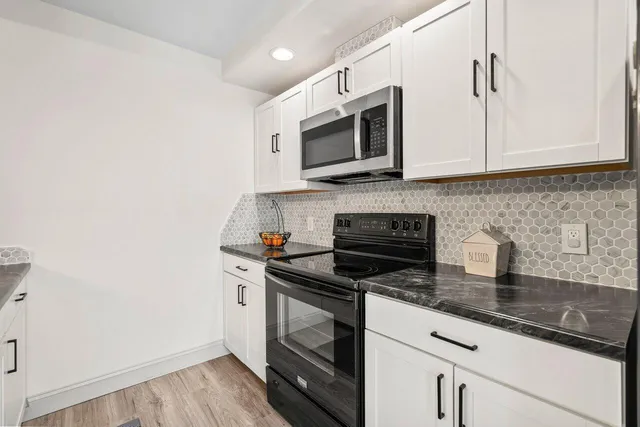 a kitchen with stainless steel appliances granite countertop a sink and a stove
