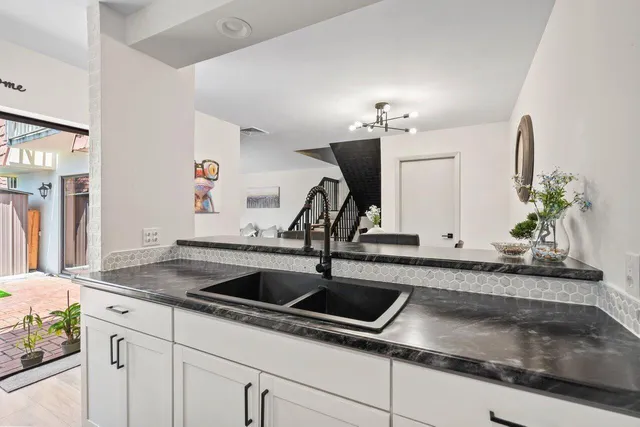 a kitchen with sink and mirror