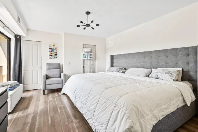 a spacious bedroom with a bed and a chandelier