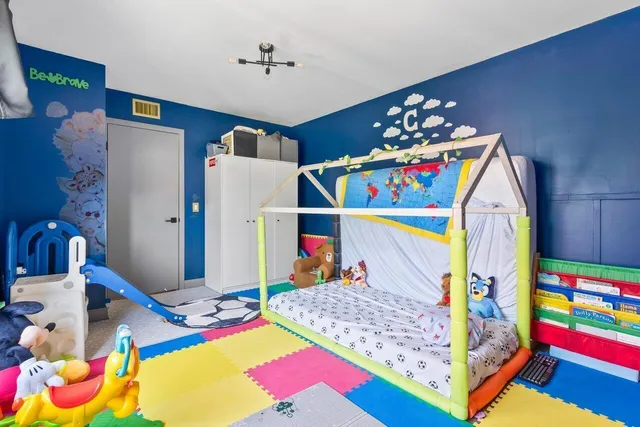 a bedroom with a bed and a wooden floor