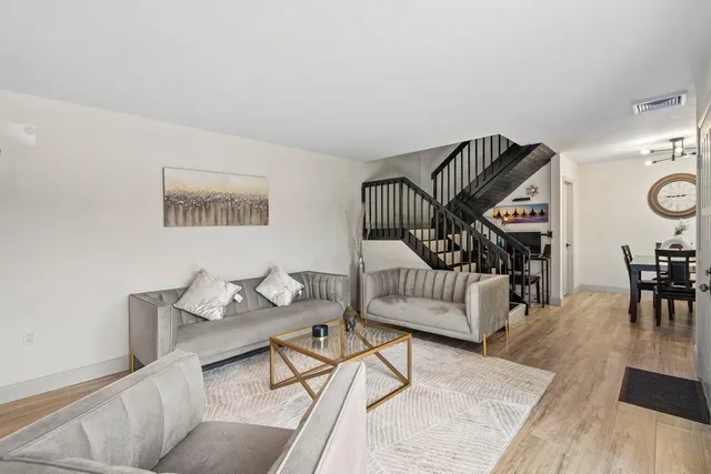 a living room with furniture and wooden floor