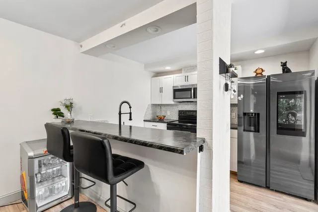 a kitchen with stainless steel appliances granite countertop a refrigerator and a stove top oven