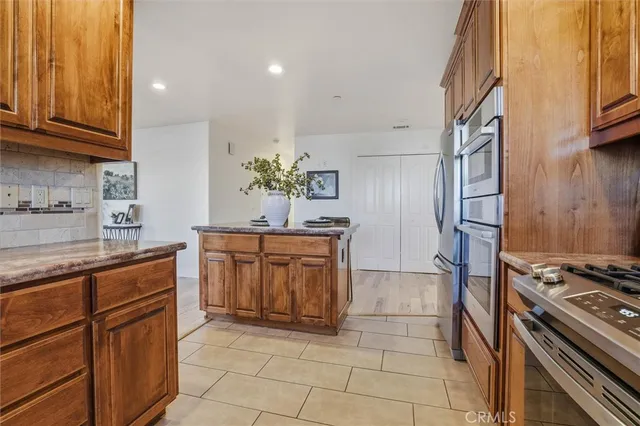 a kitchen with stainless steel appliances granite countertop a stove microwave and cabinets