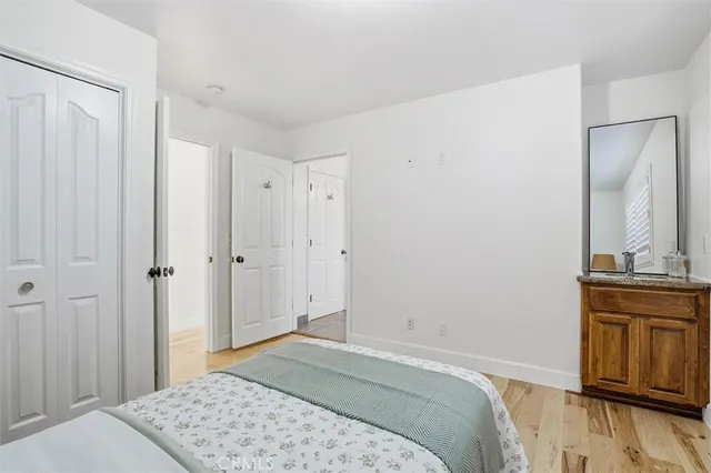 a bedroom with a bed and wooden floor