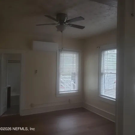 an empty room with a window and a fan