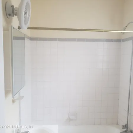 a white toilet sitting next to a shower