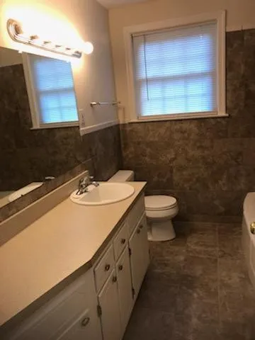 a bathroom with a sink toilet and mirror