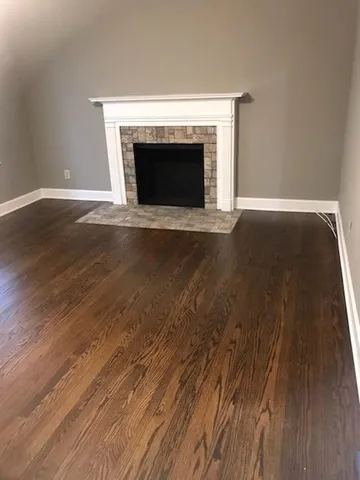 a view of empty room with wooden floor and fireplace