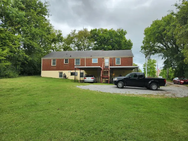 a view of a house with a big yard and sitting area