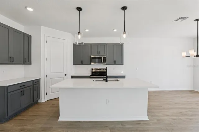 a kitchen with kitchen island a sink stainless steel appliances and cabinets