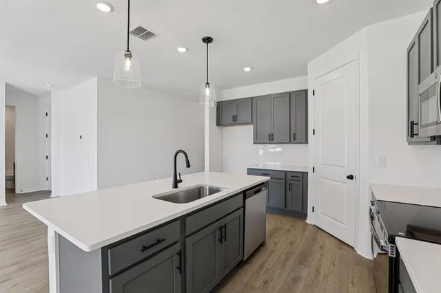a kitchen with a sink a stove a refrigerator and cabinets