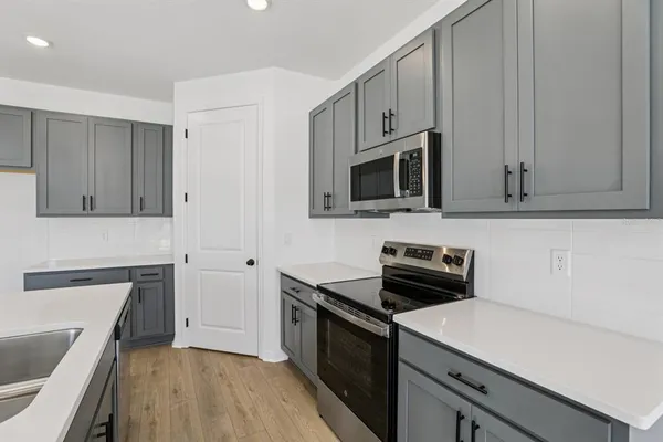 a kitchen with a sink stove and microwave