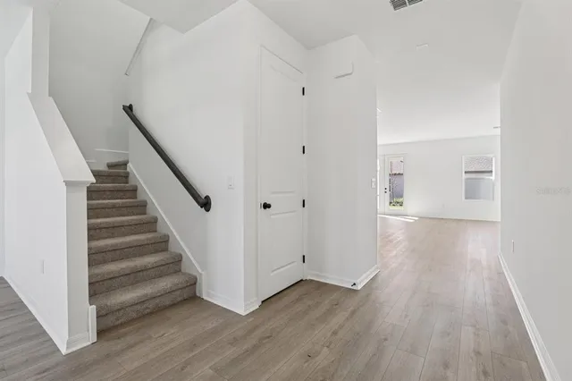 a view of a hallway with wooden floor and entryway