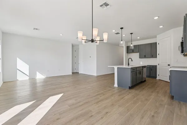 a view of a kitchen with kitchen island a sink stainless steel appliances and cabinets