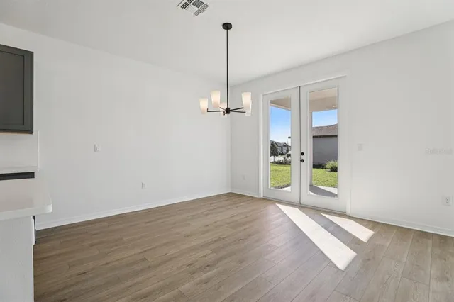 a view of a room with wooden floor and a window