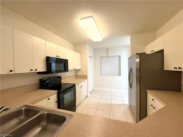 a kitchen that has a microwave a sink and a stove in it