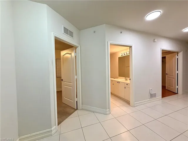 a view of a hallway with wooden cabinets