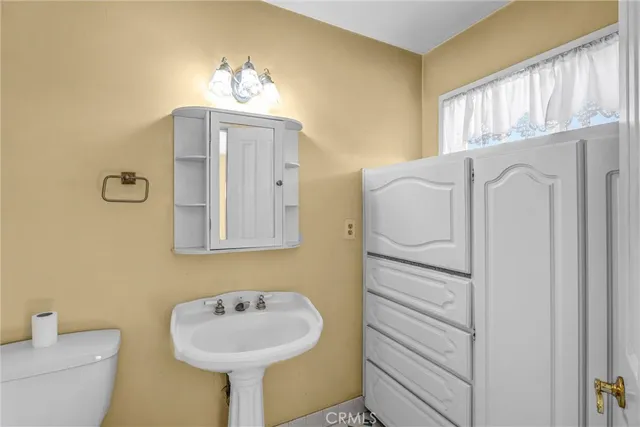 a bathroom with a sink a mirror and a toilet