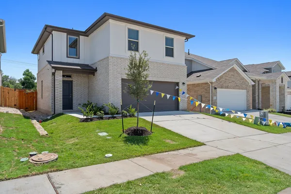 a front view of a house with a garden and plants