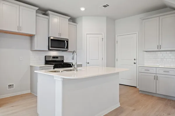 a kitchen with kitchen island a sink stainless steel appliances and cabinets