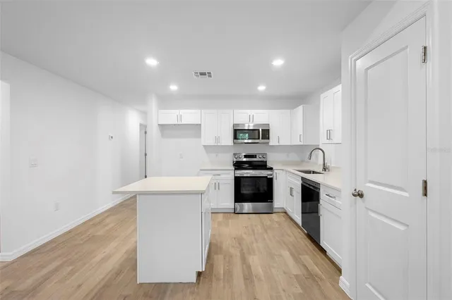 a kitchen with white cabinets and stainless steel appliances