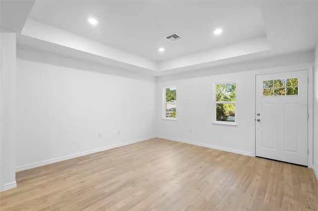 an empty room with windows and wooden floor