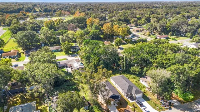 an aerial view of residential houses with outdoor space and trees