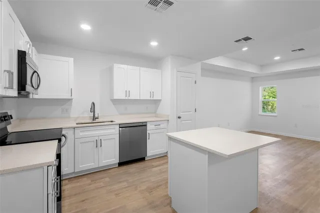 a kitchen with a sink a stove and cabinets