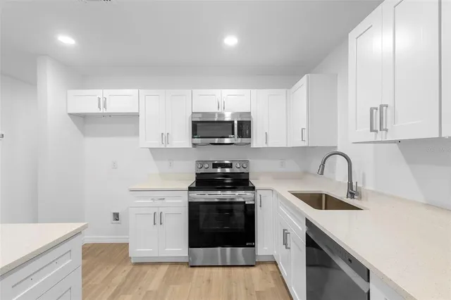 a kitchen with sink a stove and cabinets