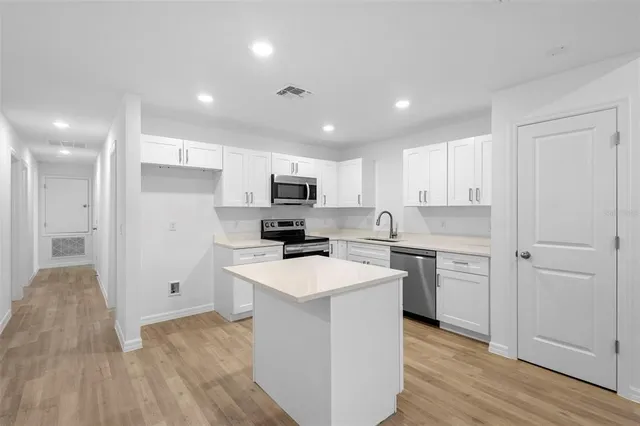 a kitchen with white cabinets and stainless steel appliances