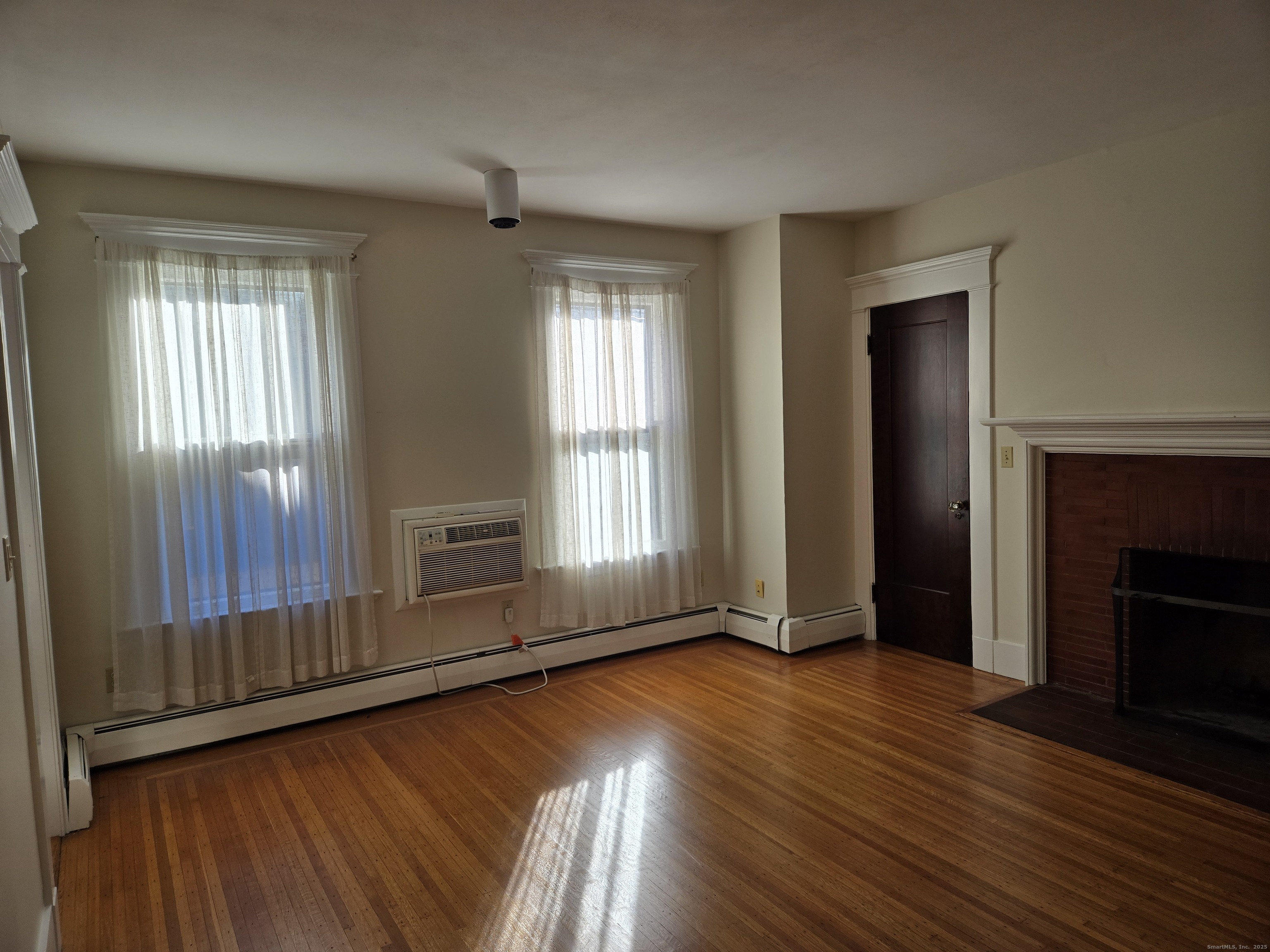 188 Cold Spring Street, Unit 4 New Haven, CT 06511 - Photo 4 of 18 an empty room with wooden floor fireplace and windows